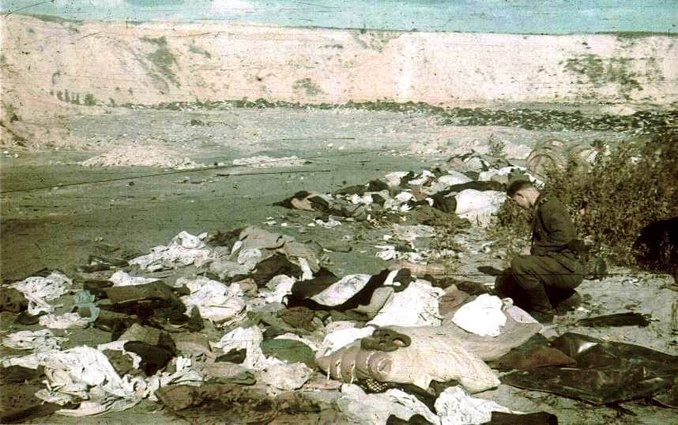 Немецкий солдат копается в вещах уничтоженных евреев, сентябрь 1941 года